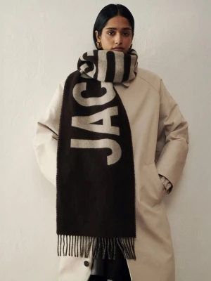 Brun halsduk från Jacquemus i Virgin Wool - Nypris 2200kr Snygg brun halsduk från Jacquemus tillverkad i 100% Virgin Ull med stor vit logotyp längs hela halsduken. Tillverkad i mjukt material och har fransar i ändarna. Perfekt accessoar för att lyfta din outfit med en trendig touch.