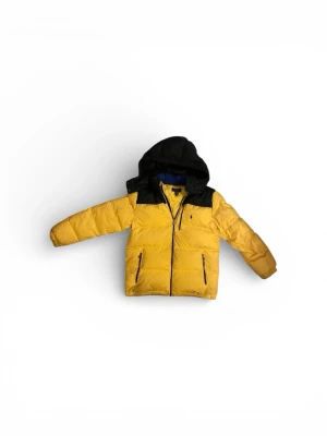 Gul pufferjacka från Polo Ralph Lauren - Grym gul pufferjacka från Polo Ralph Lauren med svarta detaljer och huva. Jackan har dragkedja framtill, två fickor med dragkedja och ikoniska Polo-loggan broderad på bröstet. Perfekt för kalla dagar och riktigt snygg streetstil. L 14-16 passar mellan 150-164 cm