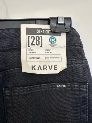 Helt nya! Svarta straight jeans från Karve - Säljer ett par svarta straight fit jeans från Karve i storlek 28. Jeansen har klassisk femficksdesign, stone wash-finish och är tillverkade av 100% återvunnen bomull. Perfekta för en clean och avslappnad look.