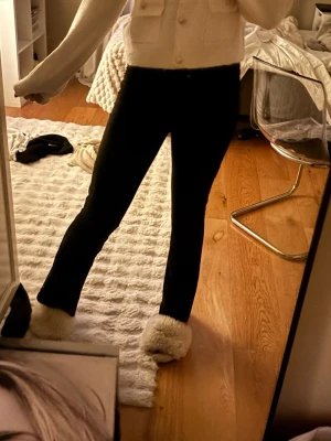Svarta utsvängda leggins/kostymbyxor - Säljer ett par svarta TYP kostymbyxor i legginsmaterual (så sköna) med utsvängda ben. De har hög midja och sitter tight upptill för en snygg siluett. Perfekta att styla med en stickad tröja eller crop top. Materialet är stretchigt och bekvämt.