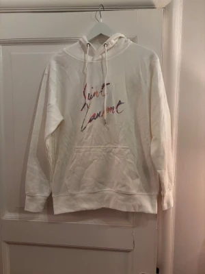 Vit Saint Laurent Hoodie  - Vit Saint Laurent Hoodie. Storlek: M, sitter mer som S. Skick: 9/10. Fraktar inom 24 timmar. Fråga på!
