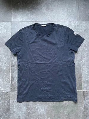 Moncler t shirt  - Tjena, säljer nu denna riktigt snygga och populära Moncler t shirten i bra skick, inga skador endast använd, storlek L, färgen är mörkblå, hör av er vid frågor och funderingar🙌🤝 