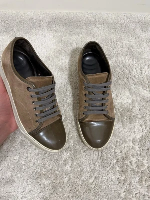 Bruna sneakers med lackad tå - Säljer dessa riktigt feta lanvin cap toe. Riktigt fräsch brun färg som passar till allt. Bättre pris hittar du inte✅