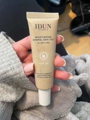 IDUN Minerals Mineral Skin Tint Light/Medium - Moisturizing Mineral Skin Tint från IDUN Minerals i färgen Kungsholmen Light/Medium. Tuben innehåller 27 ml och har SPF 30. Produkten är en färgad dagkräm som jämnar ut hudtonen, skyddar och återfuktar. Passar alla hudtyper och har en lätt beige ton.