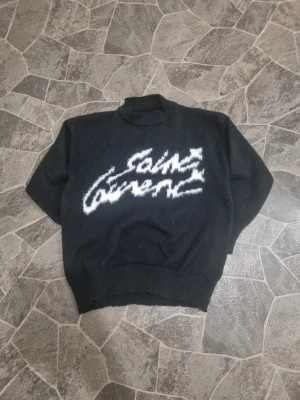 Svart stickad Saint Laurent tröja - Tyvärr är bilderna mycket fulare på grund ut av trasig kamera fast tröjan är mycket snyggare i verkligheten och den är sprillans ny, aldrig använd pågrund ut av att jag inte passat i den och ångerrätten är slut. Jag hade tyvärr aldrig tiden att skicka tillbaka till företaget så nu säljs den