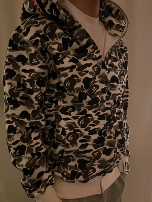 Svartvit Bape Camo Hoodie - En tredig Bape hoodie i en svartvit camo färg. Helt nytt skick och en perfekt passform.