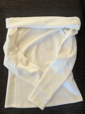 Vit offshoulder topp från Vero Moda - Säljer en snygg vit offshoulder topp från Vero Moda i mjukt material. Aldrig använd, då den ej passar mig i storleken så helt ny!