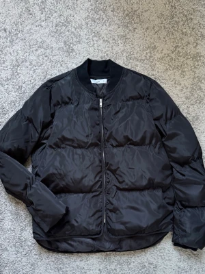 Vadderad bomberjacka  - En oanvänd bomberjacka i unisex modell storlek 38, dock overzies i storlek.