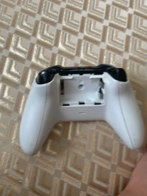Vit Xbox Series X handkontroll - Säljer en vit Xbox Series X handkontroll med svarta detaljer. Kontrollen har en ergonomisk form och är tillverkad i plast. Batteriluckan på baksidan är öppen. Passar perfekt för gaming på Xbox Series X och Series S. Men den har stikt drift 
