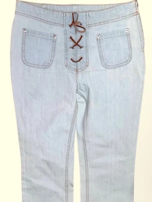 Ljusblå bootcut jeans med snörning - Snygga ljusblå jeans med bootcut passform och unik snörning framtill istället för dragkedja. 👖 Jeansen har två framfickor med synliga nitar och är tillverkade i klassisk denim. De har en dragkedja på sidan som jag tyvärr klämmer mitt fett i hahah. De är i strl 158 alltså en barnstorlek men jag får på mig dem som en storlek 34! Men kan inte röra mig så bra i dem så de passar nog bättre på någon som är strl 32/34!🥰🥰 Passar perfekt i längden dock och jag är 164 cm! Skriv vid frågor!❤️