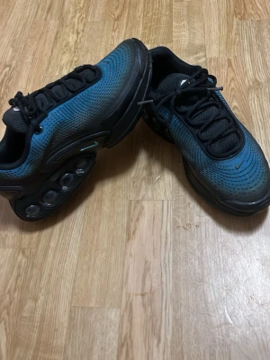 Nike Air Max blå och svarta sneakers - Nike Air Max sneakers i blått och svart med coolt mönster på ovandelen. Skorna har svarta snören, synlig Air Max-dämpning i sulan och meshmaterial för extra komfort. Perfekta för dig som gillar streetstyle och sportig.