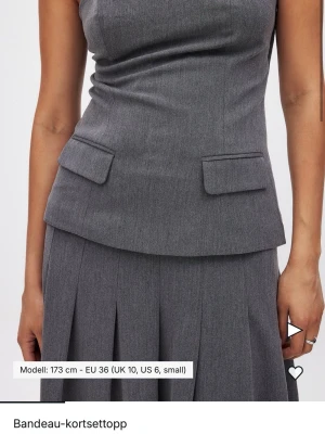 Grå bandeau korsettopp - Snygg grå bandeau korsettopp med figurnära passform. Aldrig använd.