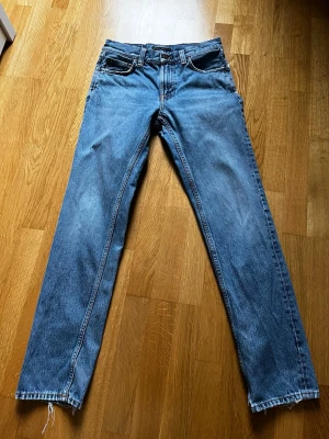 Nudie Jeans Gritty Jackson - Säljer ett par klassiska blå jeans med rak passform. Jeansen har fem fickor och normal midja. Materialet  är denim i 100% bomull. Storlek 28 32