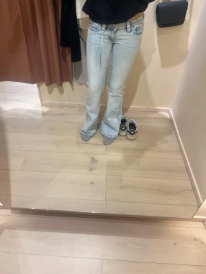 ljusblåa jeans  - Säljer ett par ljusblåa jeans som är jättelågmidjade med W på baksidorna i fluff. Har används fåtal gånger ❤️passar xs/s