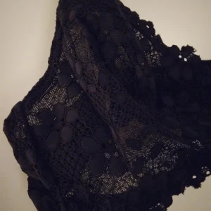 Svart mjuk spets BH / topp utan byglar, från Gina Tricot. SMALL. Fint skick. - Feminin svart mjuk spets BH utan byglar, från Gina Tricot, Strlk Small. Blommig spets, reglerbara axelband, knäppning i ryggen. Fint skick.