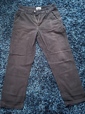 Svarta baggy byxor från New Garments XS - Snygga baggy svarta byxor från New Garments i storlek XS. Klassisk rak passform med dragkedja och knapp framtill samt sidofickor. Perfekta för en clean och stilren look. Materialet känns mjukt och bekvämt, passar till många olika outfits.