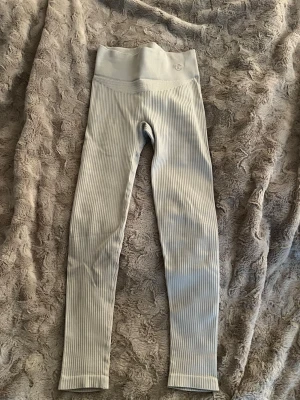 beiga träningsbyxor från iconic  - Supersnygga ribbade leggings i ljusgrått från ICONIC. Hög midja och stretchigt material som sitter skönt och formar sig efter kroppen. Passar xs/s❤️