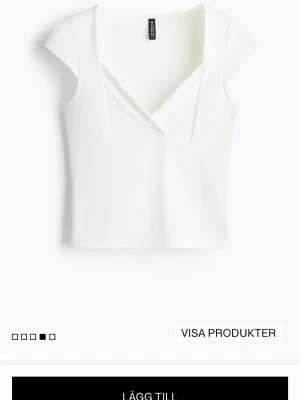 Vit omlottopp från H&M - HELT NY!! Vit topp från H&M med omlottdesign och v-ringning. Modellen är kortärmad och har en figurnära passform. Aldrig använd bara testat den på💞 Ps!! Kommer tvätta den innan jag postar! Perfekt att styla med jeans eller kjol för en fräsch look.