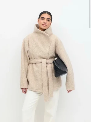 Beige teddyjacka med knytskärp från Gina  - Helt oanvänd i ny skick med prislapp! Superfin beige teddyjacka i mjukt och varmt material. Jackan har en elegant hög krage och ett bälte i midjan som ger en snygg och feminin passform. Perfekt för höst, vinter och tidig vår. i storlek xxs men passar upp till storlek S eftersom den är stor i storleken. (jag själv har Xs-S). Skriv om du vill ha bilder på 🩷