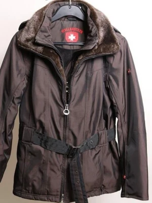 Brun jacka med fuskpäls från Wellensteyn - Snygg brun jacka från Wellensteyn med fuskpäls vid kragen, avtagbar huva och bälte i midjan. Jackan har dragkedja framtill och flera praktiska fickor. Perfekt för kyligare dagar och har en modern, figurnära passform.