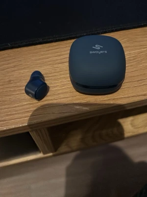 Swayers trådlösa in-ear hörlurar blå - Snygga trådlösa in-ear hörlurar från Swayers i matt mörkblå färg. Kommer med ett matchande laddningsetui i samma färg och rundad form. Perfekta för musik, poddar eller samtal på språng. Smidig och kompakt design som är lätt att ta med sig. Haft de i 3 veckor.