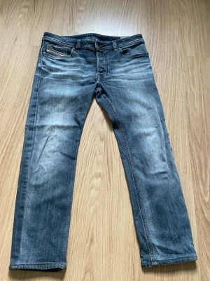 Blå raka jeans från Diesel - Säljer ett par klassiska blå jeans från Diesel med raka ben med snygga slitningar.                           Är straight i passform 