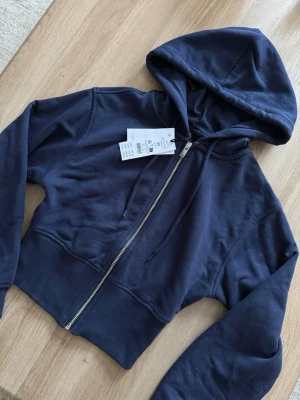Zip hoodie - Helt ny med prislapp, inköpt nyligen från Gina Tricot. Sitter jättefint på och framhäver midjan, storlek XS