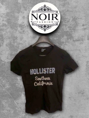 Svart Hollister t-shirt - Snygg svart t-shirt från Hollister med trycket 'Hollister Southern California' i vitt och ljusblått på bröstet. Klassisk passform och rund halsringning, perfekt till jeans eller shorts.