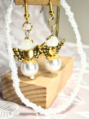 Paket: Armband och Guldiga ängel örhängen med pärlor - Ett elegant armband i glaspärlor med matchande örhängen med änglar.  Örhängeskrokarna är guldpläterade.  Nytt med prislapp, handmålad etikett med texten Pearl Angel.  De färgglada glaspärlorna är 3 mm i diameter. Armbandet är 18 cm i omkrets med stretchigt och hållbart kristallband.  Perfekt som present eller en härlig unik detalj till dig själv. Denna storlek passar de allra flesta vuxna kvinnor, skulle du behöva ändra storleken är du varmt välkommen att höra av dig. Perfekta för dig som vill s