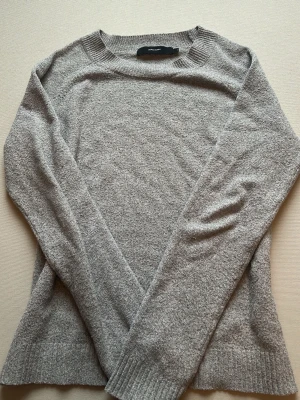 Grå stickad tröja från Vero Moda - Mysig grå stickad tröja från Vero Moda med rund halsringning och långa ärmar. Säljer eftersom att den är för lång på mig. Jag har normalt storlek S i tröjor men den här tröjan var lite större än vad jag trodde, skulle säga att det är en storlek M