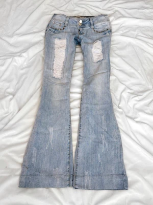 Ljusblå superlågmidjade jeans med slitningar - Sååå sjukt snygga vintage superlågmidjade jeans med slitningar!😩😩💓💓säljer eftersom de inte passar därför har jag ingen bild på! 💓   Innebenslängd: 76 midjemått: 36