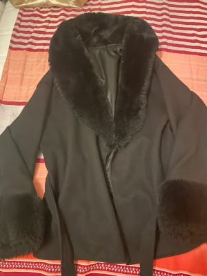 Svart kappa  - Svart kappa kort exakt vid midjan perfekt för hösten och kan användas för vintern 