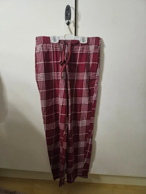 Rödrutiga pyjamasbyxor från kappahl - Snygga röd-rutiga byxor från Kappahl i storlek XS. Byxorna har vitt rutmönster, elastisk midja med snörning och är gjorda i mjuk bomull. Passformen är någor kortare, skriv om ni vill ha specifika mått. Använt endast ett fåtal gånger, men i mycket bra skick. Nypris runt 200 kr. 💓