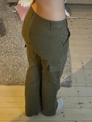 Olivgröna cargobyxor  - Säljer ett par olivgröna cargobyxor med raka ben och flera  fickor på sidorna och bak🤎