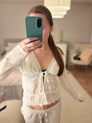 Gullig vit blus med brodyr och spets - En gullig vit blus från Zara, med spets och broderier. Finns knappar nere vid ärmen och öppen vid magen! Perfekt som en blus eller strandtopp🩷 