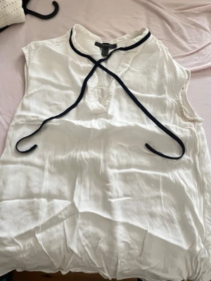 Vit ärmlös blus från Esprit - Snygg vit blus från Esprit i storlek 38. Blusen är ärmlös och har en avslappnad passform med rundad halsringning. Tillverkad i ett lätt och luftigt material, perfekt för varma dagar. Enkel att matcha med både jeans och kjol.