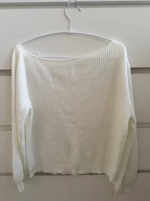 Vit ribbstickad off shoulder-tröja - Säljer en vit ribbstickad tröja med off shoulder-modell. Tröjan har långa ärmar och en lös, avslappnad passform. Materialet känns mjukt och bekvämt mot huden💞