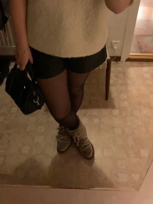 Svarta shorts i skinnimittation  - Säljer ett par as snygga skinn shorts från hm. De är relativt högmidjade men blir as snyggt om man har på sig en längre tröja över som i bilden 💕