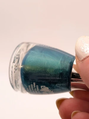 Yes Love turkost glittrigt nagellack nästan full - Nagellack från Yes Love i en snygg turkos nyans med metallisk och skimrande finish. Flaskan rymmer 15 ml och har en elegant, rundad form med silverfärgat lock. Perfekt för dig som vill ha färgstarka och glansiga naglar.