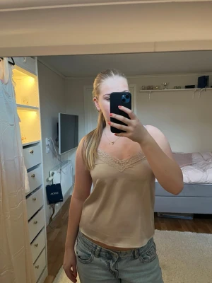 Champagnefärgat linne med spets - Supersöt champagnefärgat linne från Kappah men justerbara band. Säljer då den tyvärr har blivit för liten.