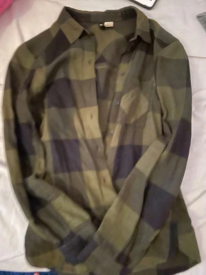 Mörkgrön rutig skjorta - Mörkgrön rutig skjorta från H&M i storlek 32. 