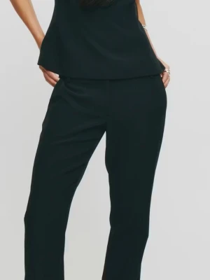 Vera kostymbyxor  - Stilrena svarta kostymbyxor med rak passform och hög midja. Byxorna har diskreta fickor i sidorna och är tillverkade i ett mjukt, vävt material som ger en dressad look. Perfekta för en clean och modern stil.