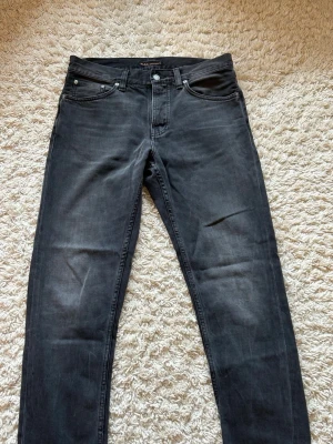 Mörkgrå/svarta Nudie Jeans - Säljer ett par sjukt snygga mörkgrå/svarta Nudie Jeans i modellen Steady Eddie II. Storlek W31 L30 Mycket bra skick, inga tecken på slitage Priset är ej hugget i sten  Skriv gärna vid frågor!