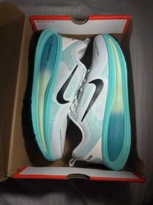 Nike ZoomX vita och turkosa sneakers - Säljer ett par Nike Vomero 18 i färgen Summit White / Black / Cactus. Storlek EU 44.  Skorna är i mycket fint skick och nästan inte använda. Inga större märken eller slitage. Perfekta som löparskor eller vardagsskor då de är väldigt bekväma.  Originalkartong följer med.  Modell: Nike Vomero 18 Färg: Vit / turkos / svart Storlek: 44 (US 10) Skick: Mycket bra  Skickas snabbt eller kan mötas upp i Stockholm.