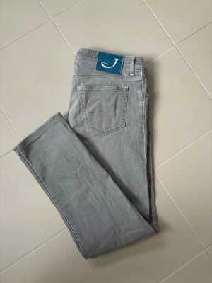 Jacob Cohen jeans w36 - Extremt snygga sällsynta trendiga och eftertraktade grå Jacob Cohen jeans i w36 säljes. 47 cm breda och 106 cm total längd. Grym passform i Toppenskick utan hål eller fläckar och en nyare model. Verkligen superfint skick och jättesnygg tvätt! Perfekta nu till våren och sommaren och tveka inte vid minsta fråga!