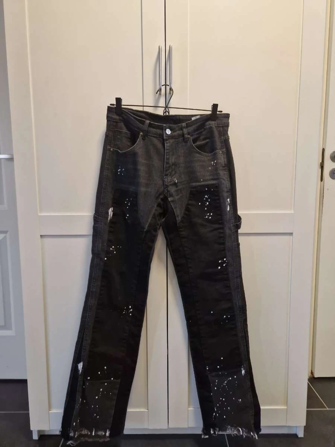 Svarta flared jeans med färgstänk och råa kanter
