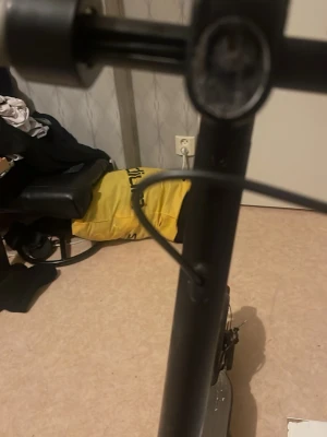 Svart elscooter med handtag - Säljer en svart elscooter med robust ram och tydligt handtag. Scootern har en bred fotplatta och synliga kablar vid styret. Perfekt för smidig transport i stan eller till skolan. Men den har punktering På ett hjul