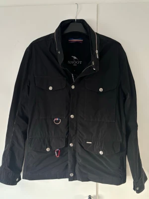 Snoot fieldjacket M herr svart - Svart trendig och populär snoot jacka av högsta kvalite i storlek M säljes! Använt men bra skick! Perfekt nu som vår och sommarjacka och grym passform!