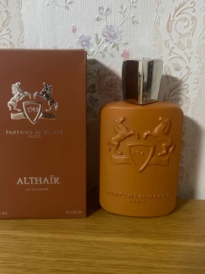 Parfums de Marly Althaïr EdP - Parfums de Marly Althaïr Eau de Parfum i packing2 och flaska i varm brun sopmat finish med silverfärgat lock. Flaskans x och logga är präglade framtill. Lyxig och elegant design som sticker ut på parfymhyllan.