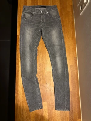 Grå slim fit jeans. Tiger of Sweden.  - Snygga grå slim fit jeans med klassisk femficksdesign och diskreta slitningar framtill. Jeansen har normal midja och raka ben, perfekta till en avslappnad stil. Tillverkade i mjukt denimtyg för skön känsla hela dagen. Storlek: 32/34. Men i själva verket passar de bättre som 30/30  